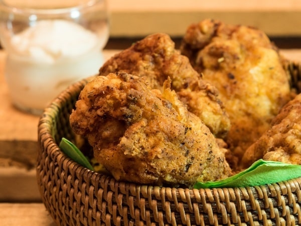 Electric Skillet Fried Chicken 2 - IntheKitch Electric skillet fried chicken in weaved basket with garlic mayo on the side and green napkins.