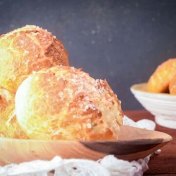 Baked pretzel bread on a wooden platter.