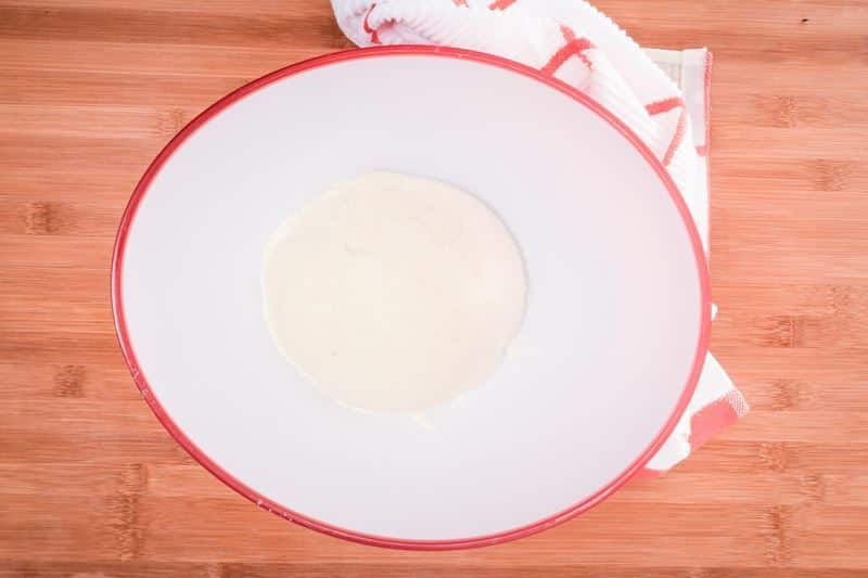 How to Make Pretzel Bread Step 10 Dough in a bowl on wooden counter.