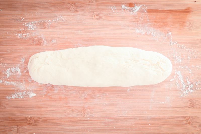 How to Make Pretzel Bread Step 12 Dough formed into a long roll on floured surface.