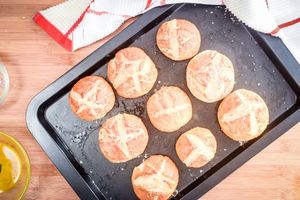 Baked pretzel rolls on a pan.
