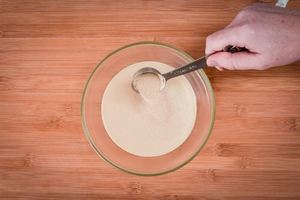 Adding yeast to water in a bowl.