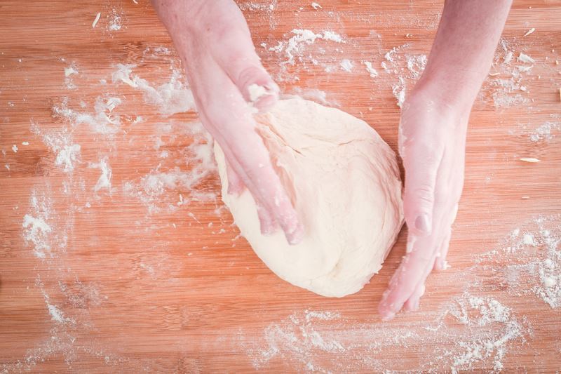 How to Make Pretzel Bread Step 9-2 Rolling dough on floured surface with hands.