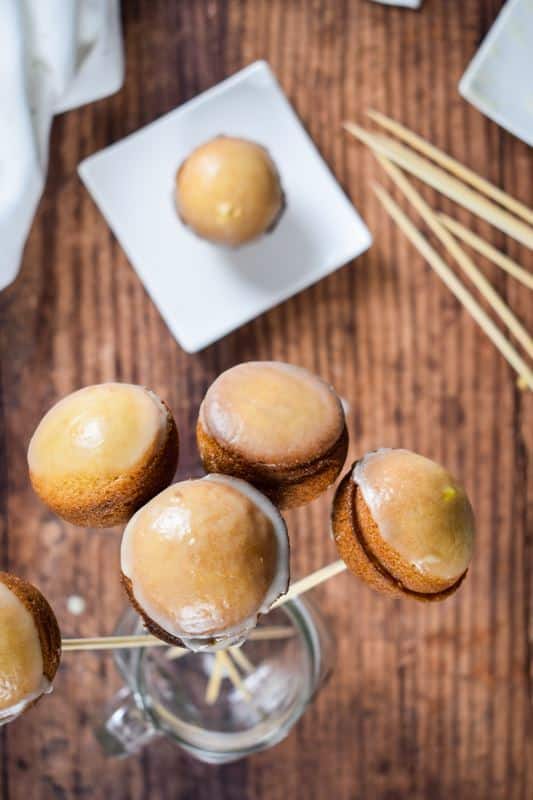 How to Make Cake Pops with a Cake Pop Maker_1 Finished, glazed cake pops in jar on wooden background.