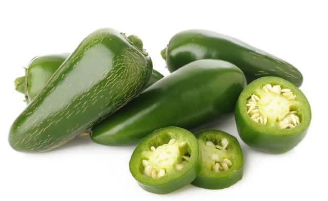 Jalapeno peppers, sliced and whole. Green jalapeno chili peppers, sliced and whole. White background.