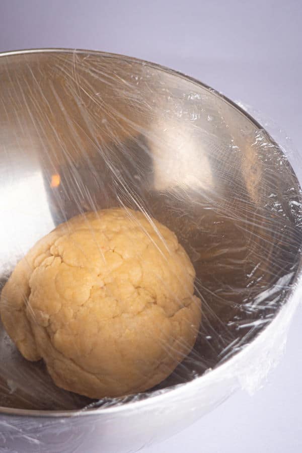 How to Make Cinnamon Rolls_11 Dough ball in bowl with plastic wrap.