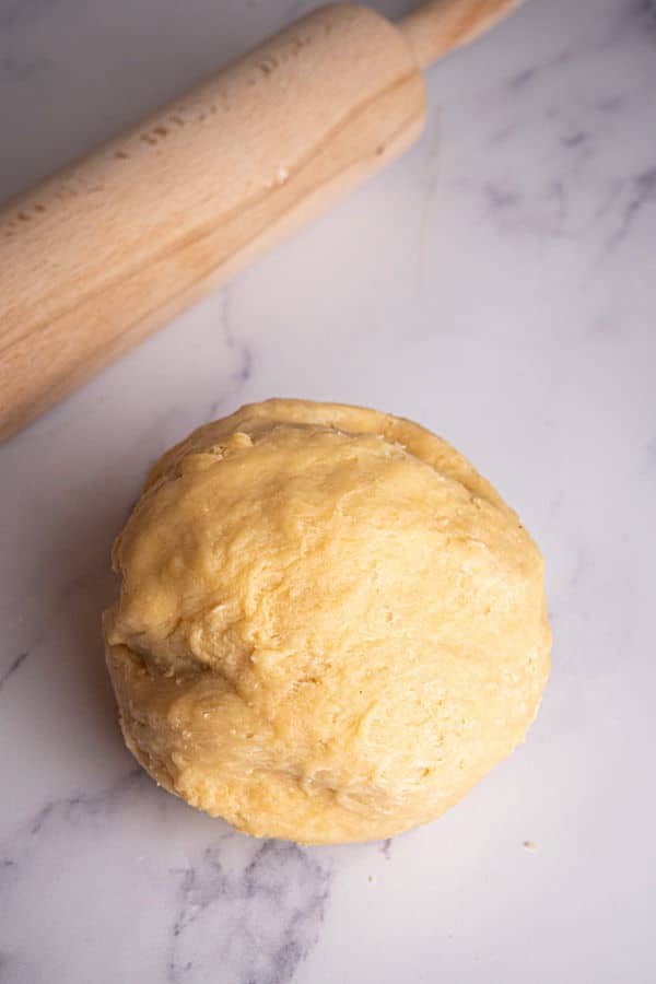 How to Make Cinnamon Rolls_12 Dough ball and rolling pin on marble counter top.