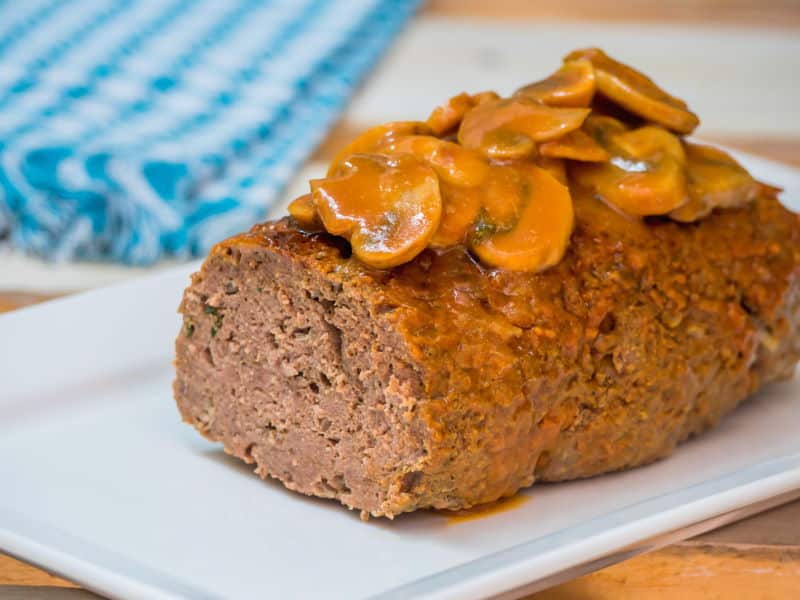 Electric Skillet Meatloaf 1 - IntheKitch Meatloaf covered in a mushroom sauce on a serving dish.
