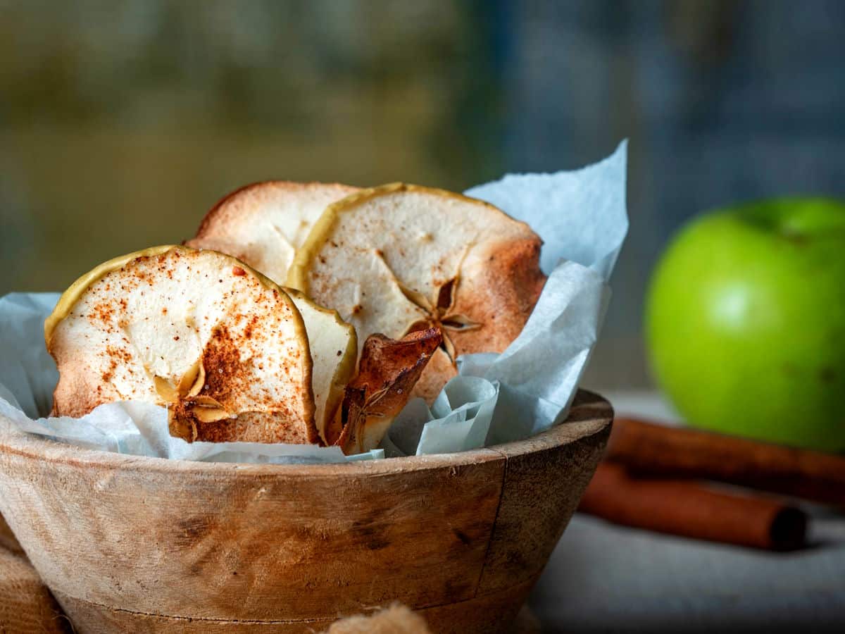 Cinnamon Apple Chips 3 Cinnamon apple chips in a wooden bowl.