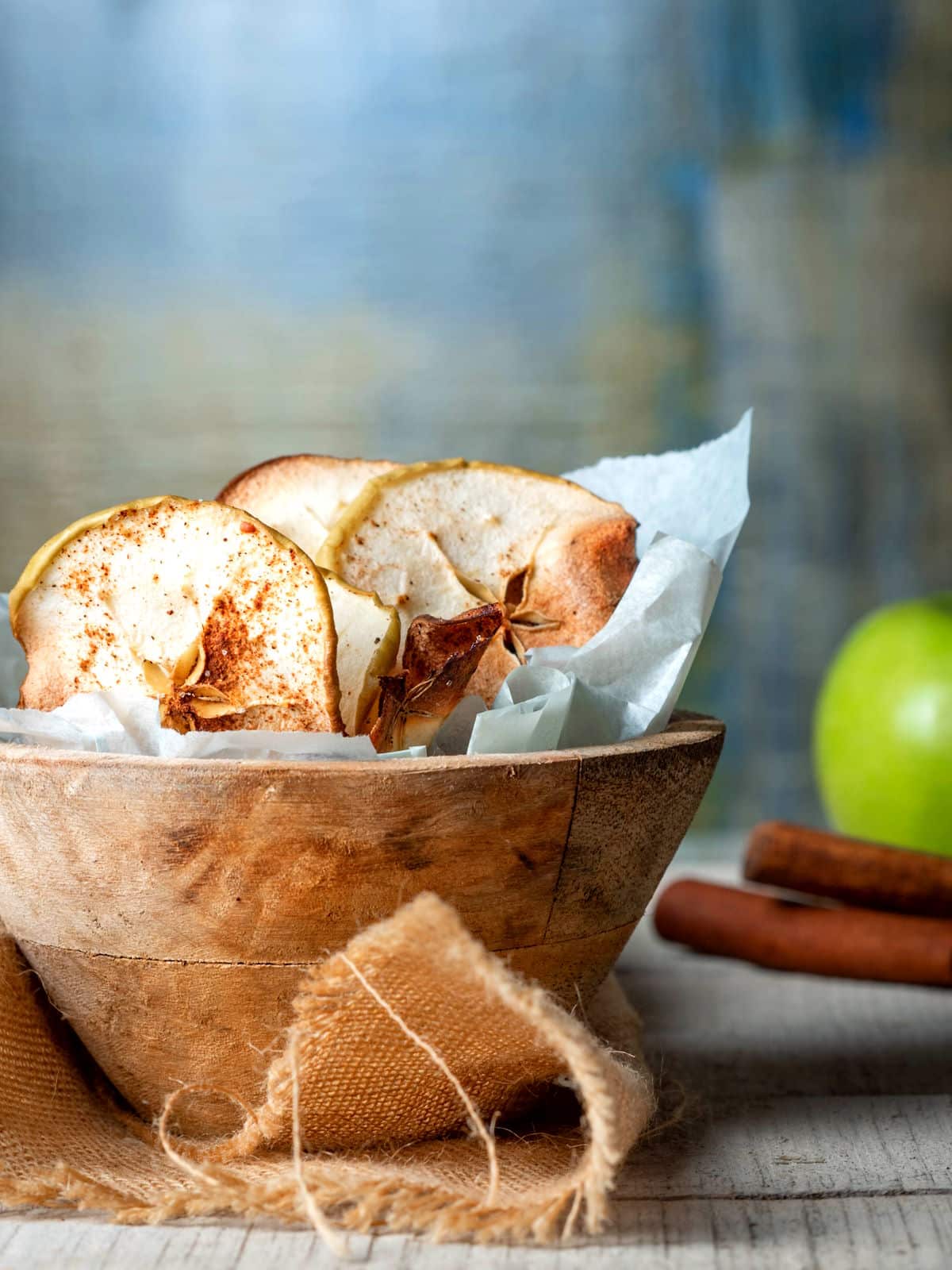 Cinnamon Apple Chips Apple chips sprinkled with cinnamon in a wooden bowl.