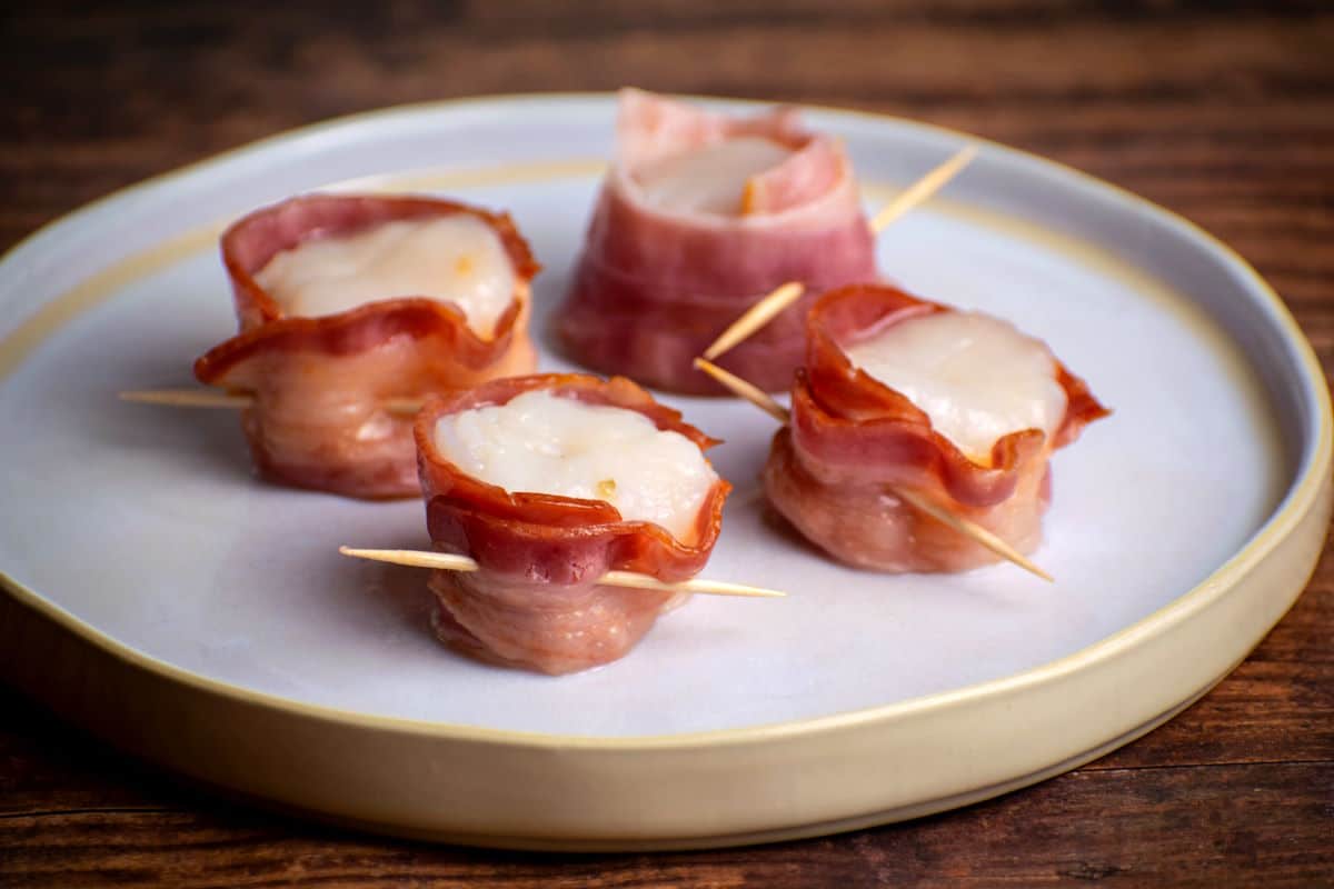 Scallops wrapped in bacon with toothpicks.