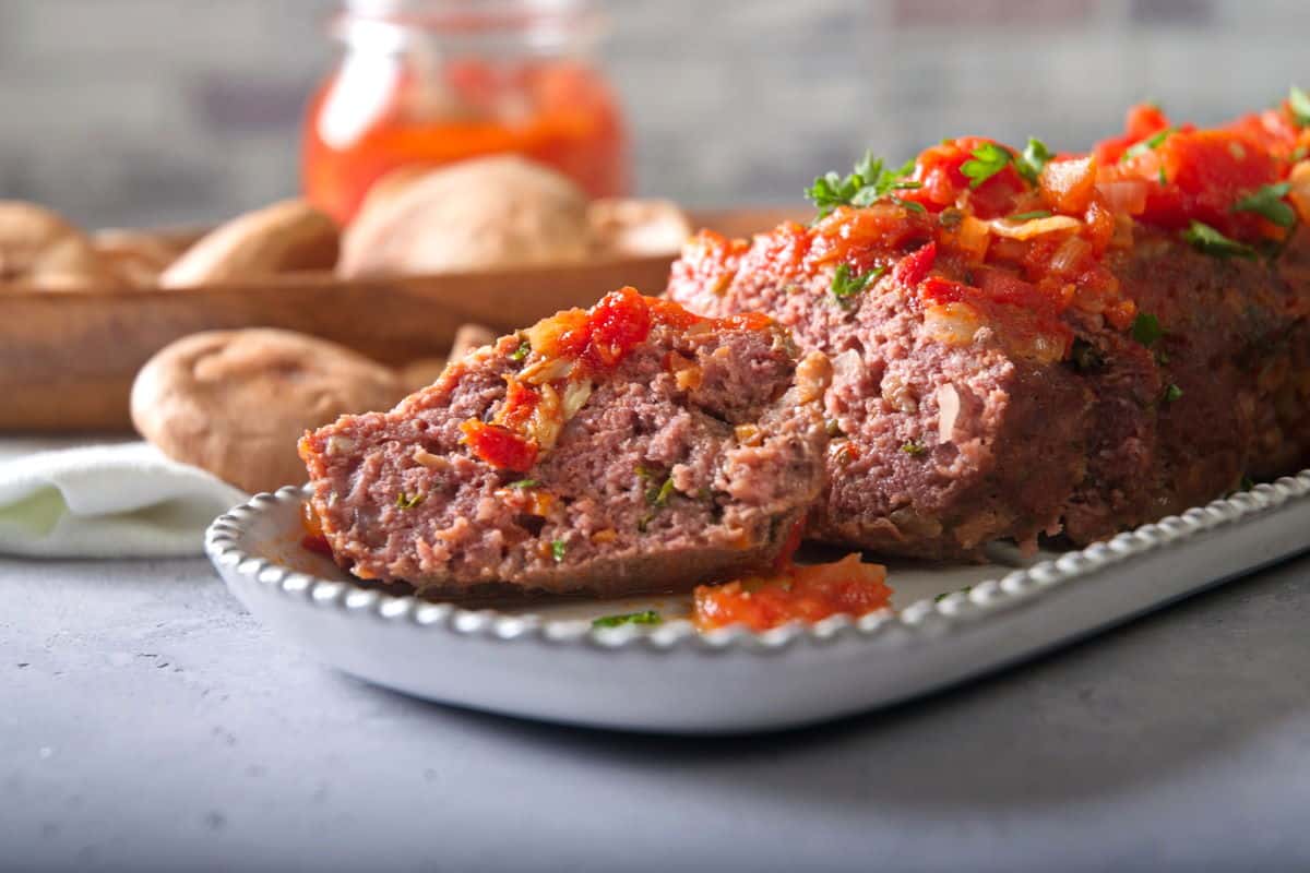 Bison meatloaf sliced on white serving dish.