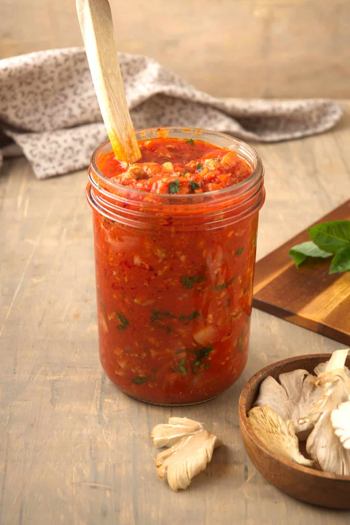 Bison meat sauce in a jar with a wooden spoon.