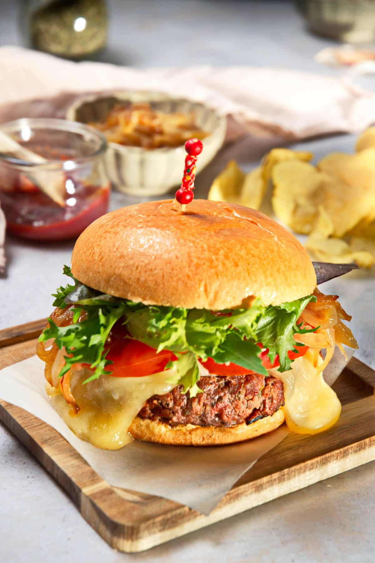 Bison burger with condiments in the background.