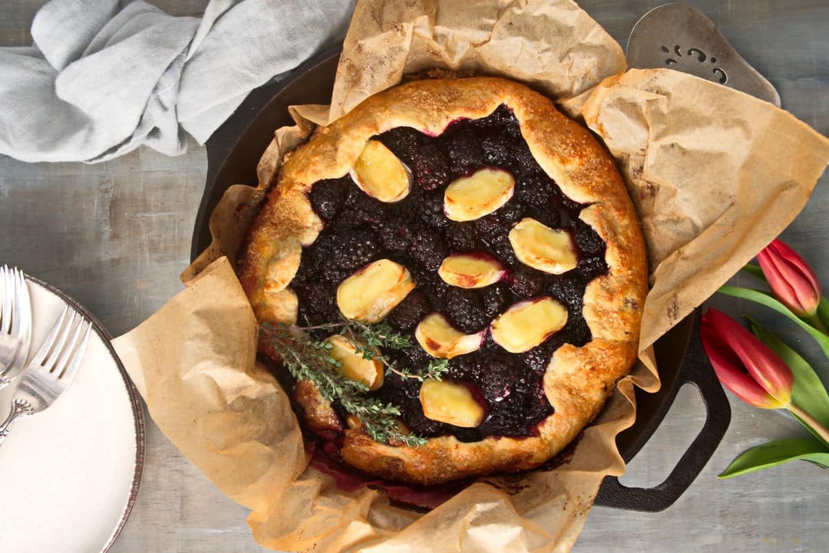 Blackberry galette with brie and thyme in a pan.