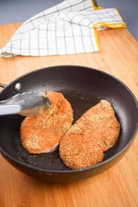 Cajun-spice covered chicken breasts in pan.