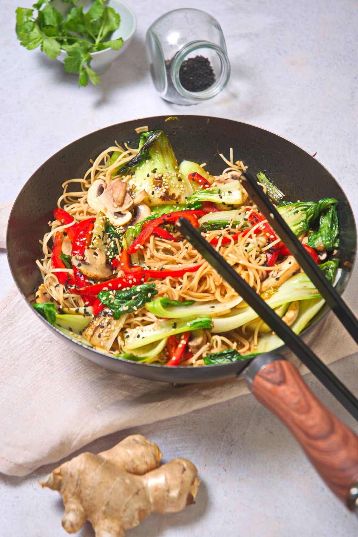 Bok choy stir fry with noodles in frying pan.