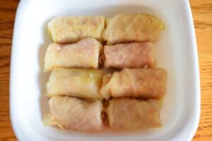 Unbaked cabbage rolls in casserole dish.