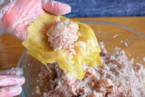 Cabbage leaf with cabbage roll stuffing in hand.