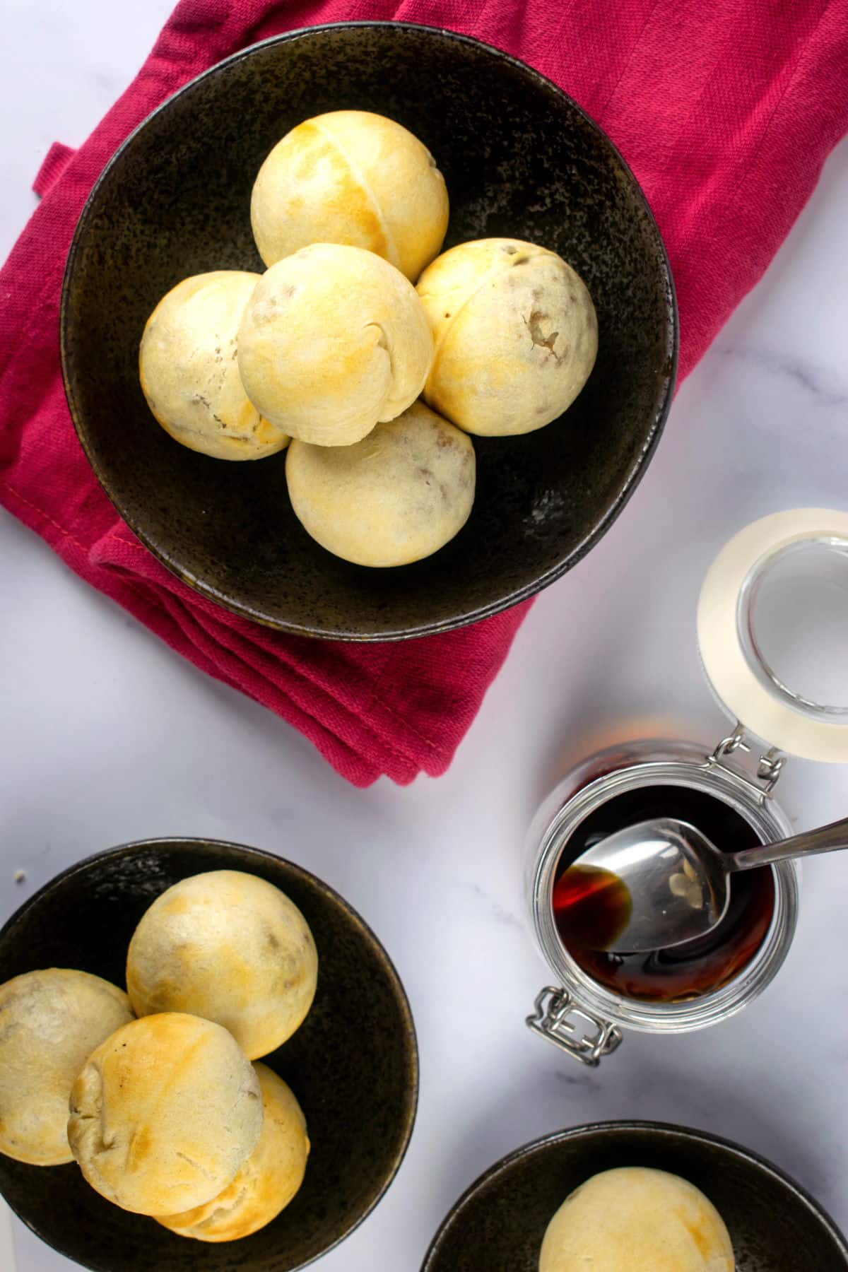 Chinese pork buns in black dishes with dipping sauce.