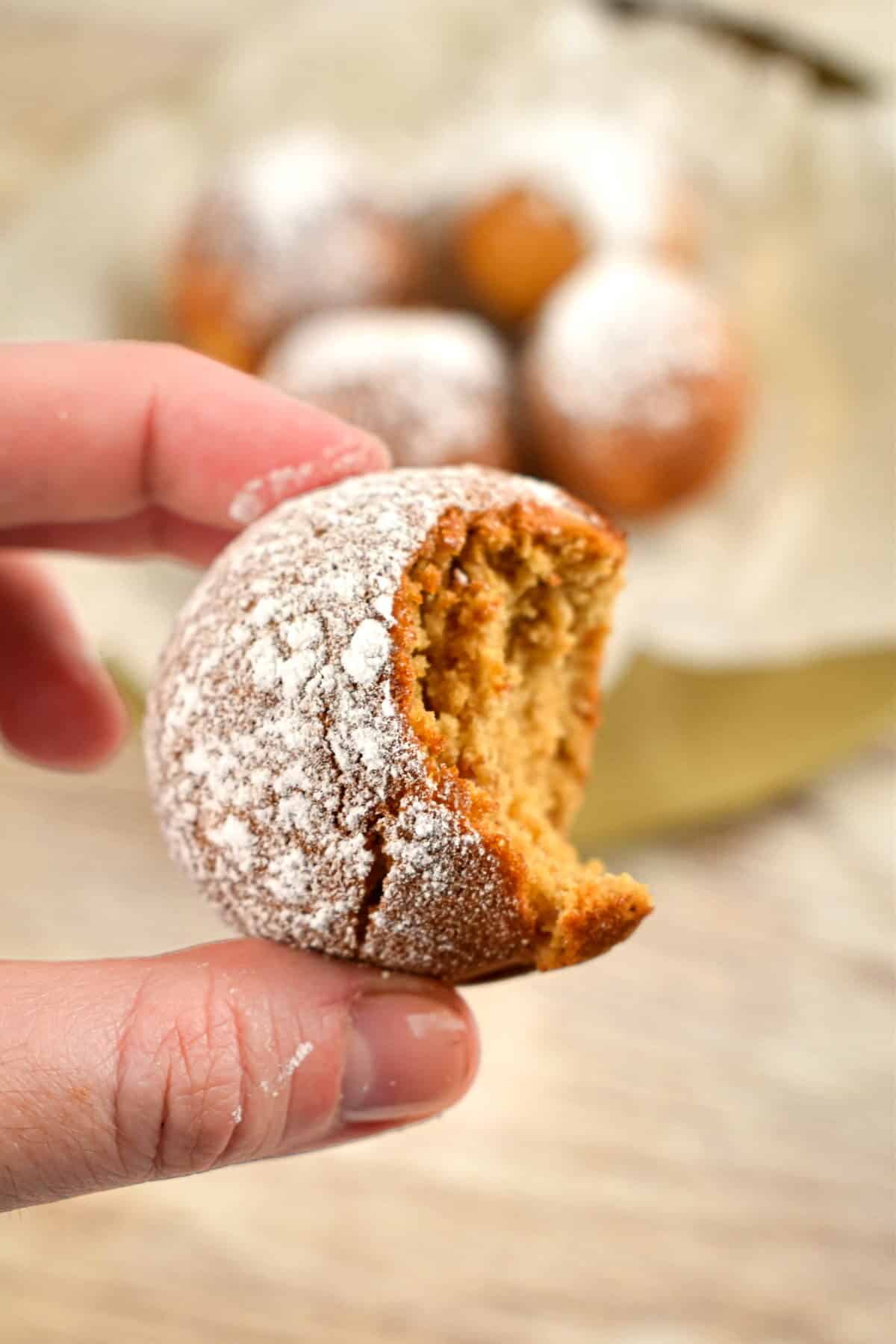 Cake Pop Maker Ginger Bread Cake Pops A hand holding a gingerbread cake pop that has been bitten into.