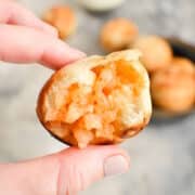 Mini shrimp ball with a bite taken out of it in hand.
