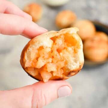Mini shrimp ball with a bite taken out of it in hand.