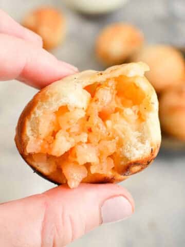 Mini shrimp ball with a bite taken out of it in hand.