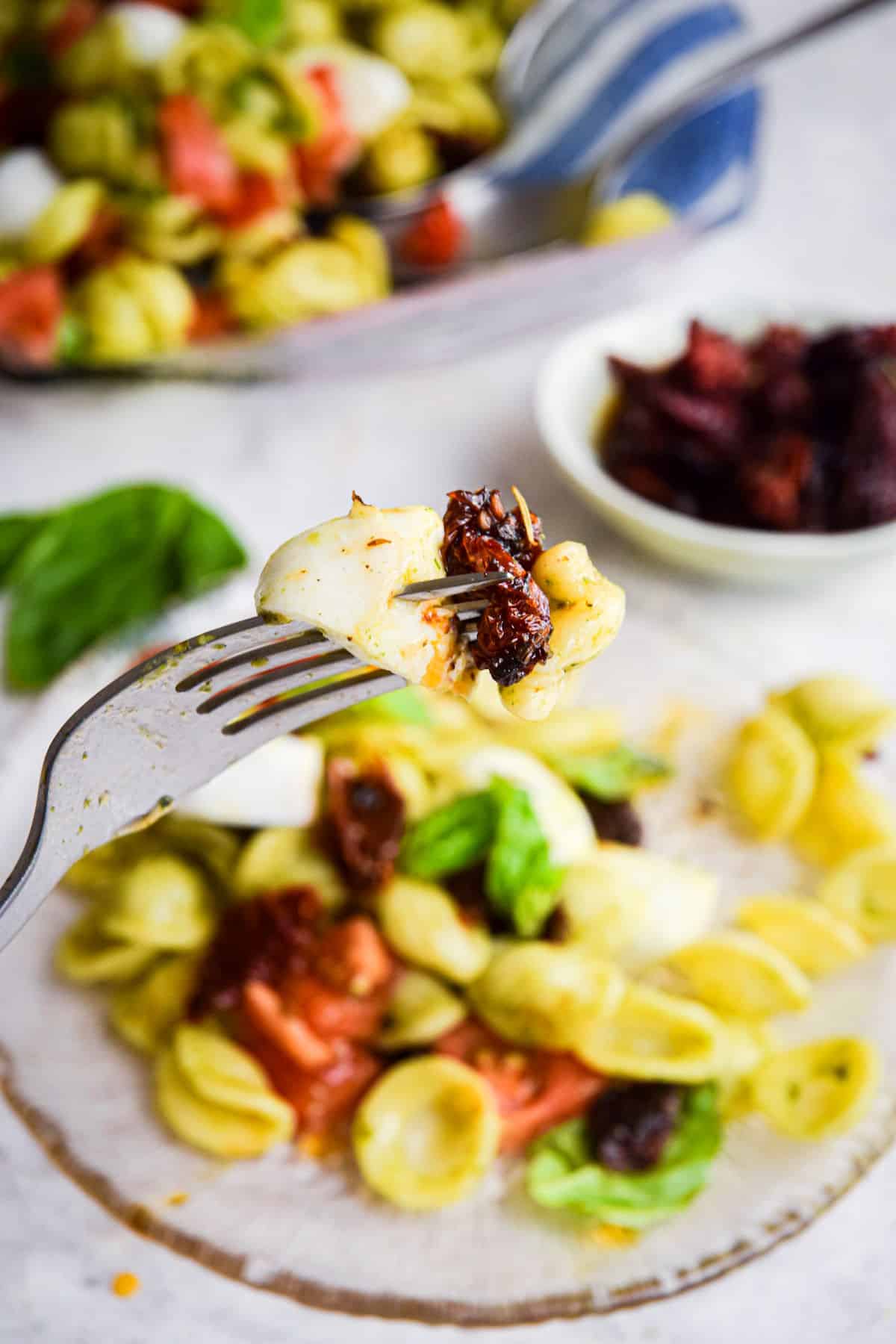 Caprese pasta salad on a fork.
