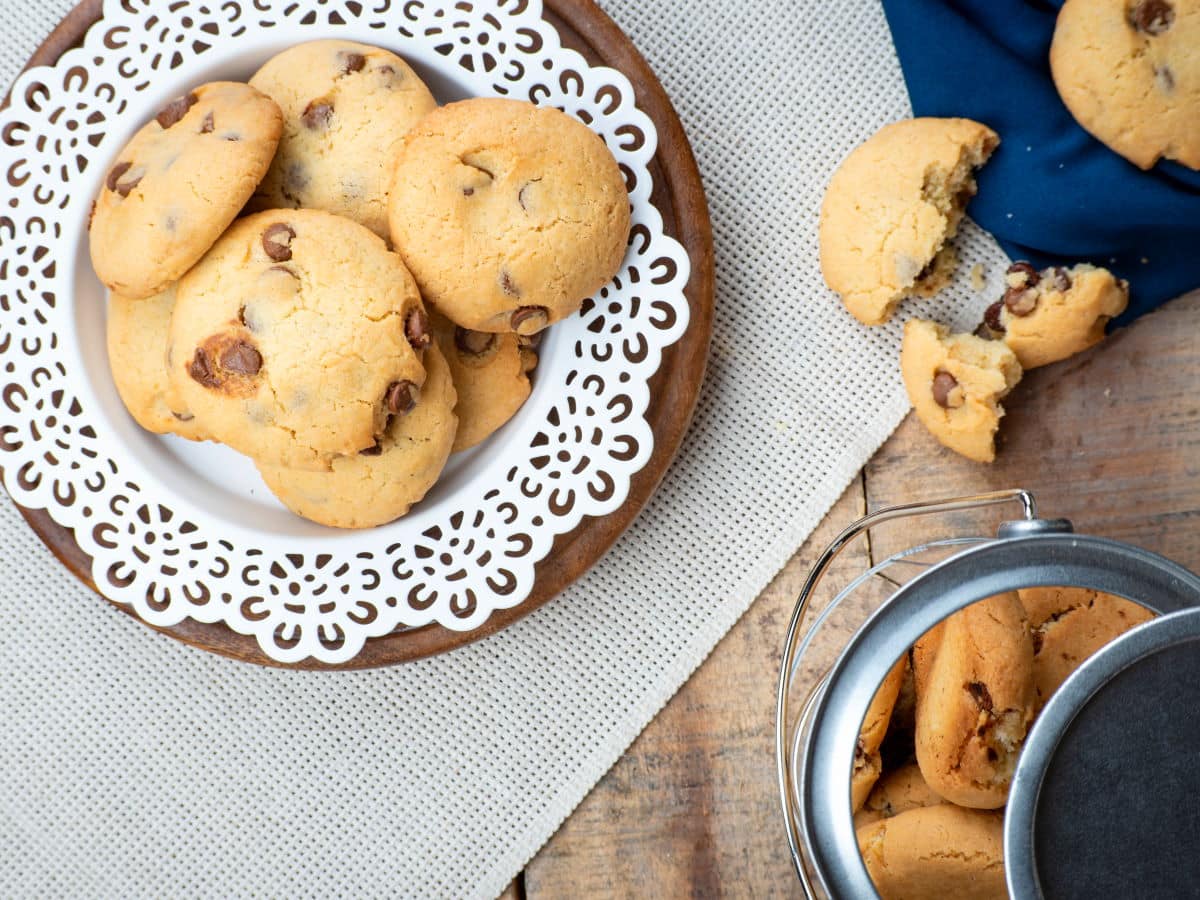 Top view of cookies on a white plate with cookie jar on the side.