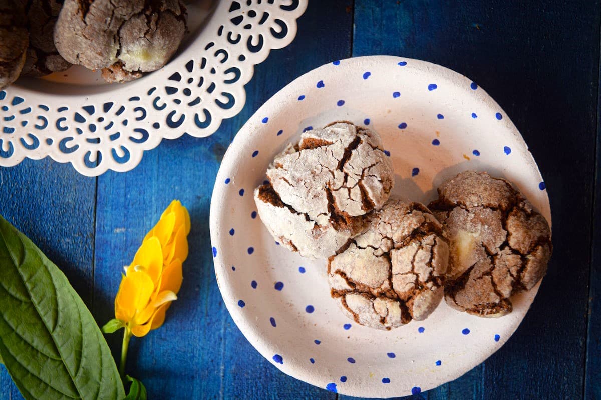 Chocolate crinkle cookies on paper plate.