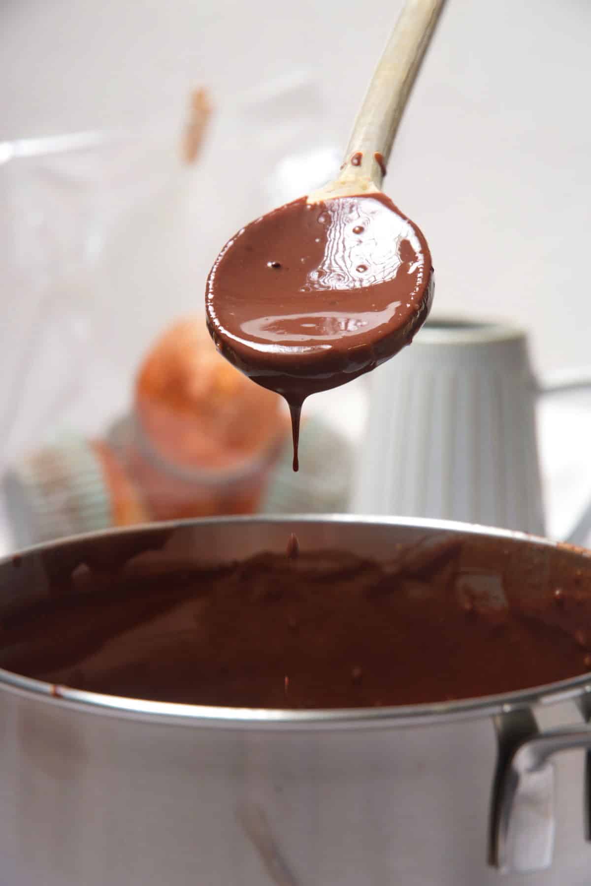 Chocolate gravy on a spoon over pot.