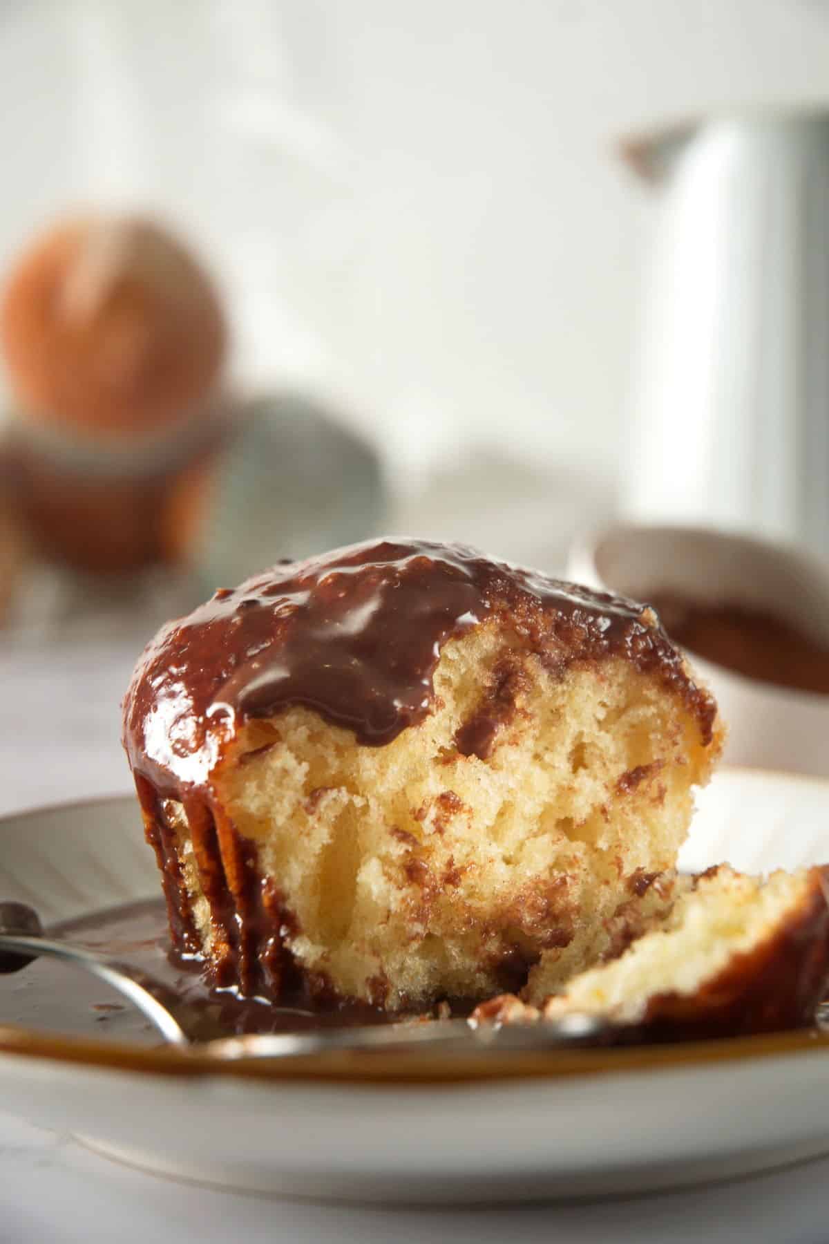 A muffin that's been sliced open and coated in chocolate gravy.