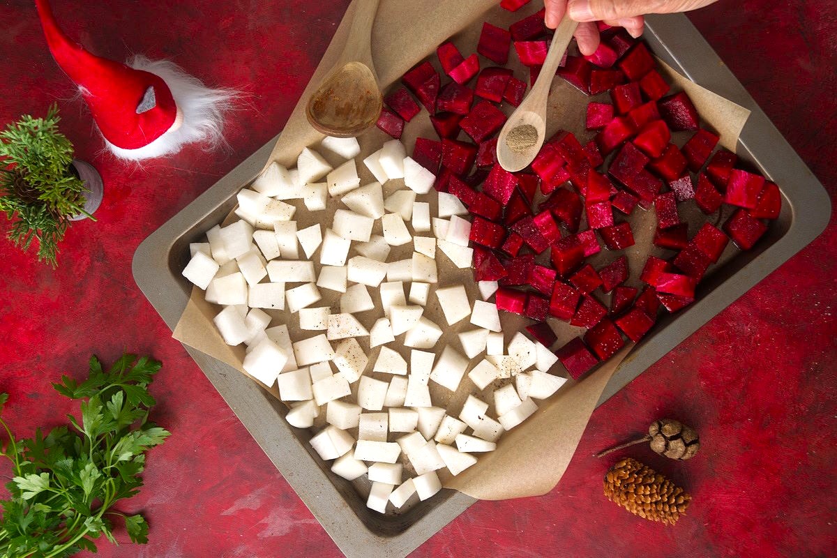 Chopped beets and turnips on a baking sheet with salt and pepper.