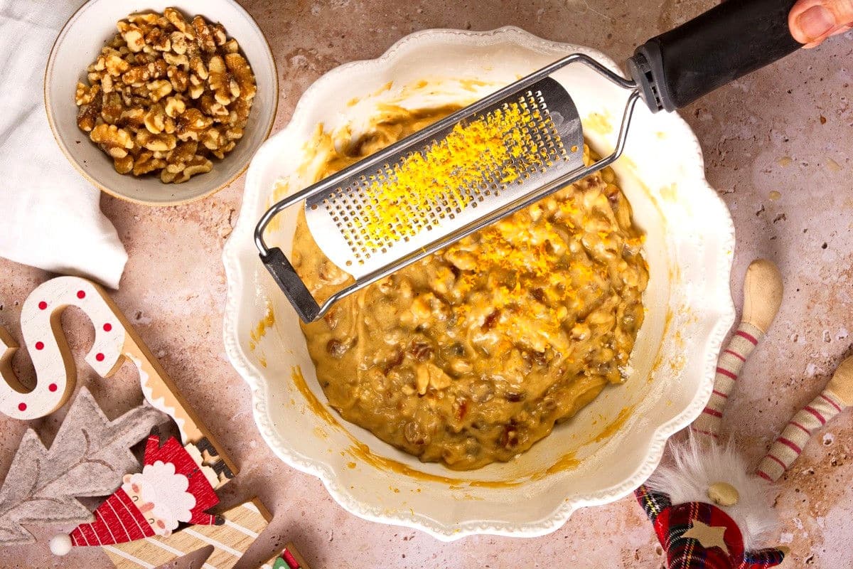 Christmas bundt cake batter with orange zest in bowl.