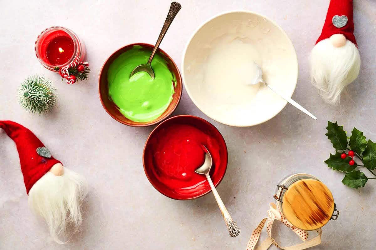 Colored Christmas sprinkle mixtures in small bowls.
