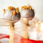Christmas spice cake pops with beige ribbons tied around the treat stick.