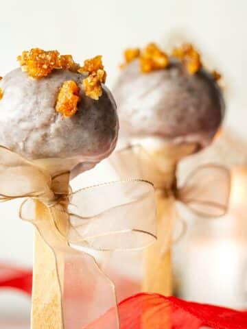 Christmas spice cake pops with beige ribbons tied around the treat stick.