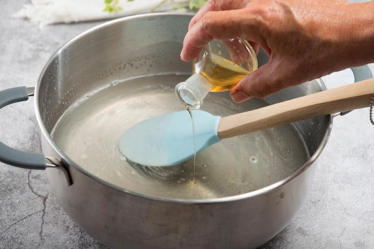 Large saucepan with gelatin mixture and a small bottle of pumpkin pie syrup.