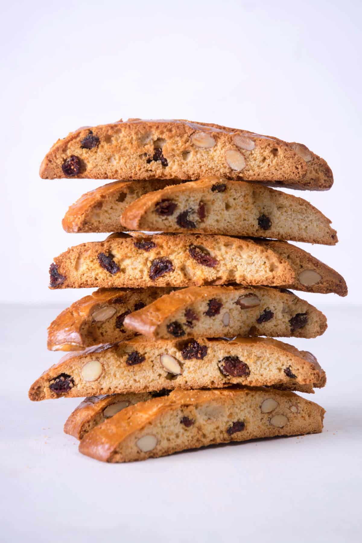Cranberry biscotti stacked on white background.