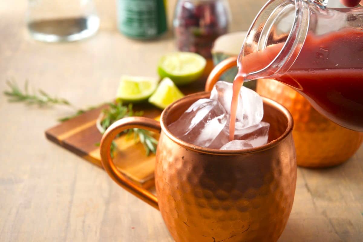 Ice and cranberry juice in copper mug.