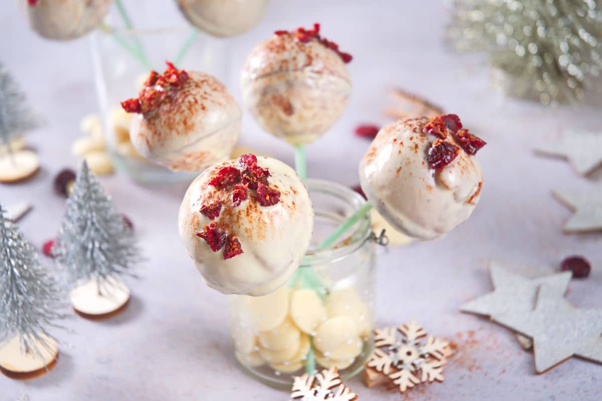 Cranberry white chocolate cake pops in jar with Christmas decorations.