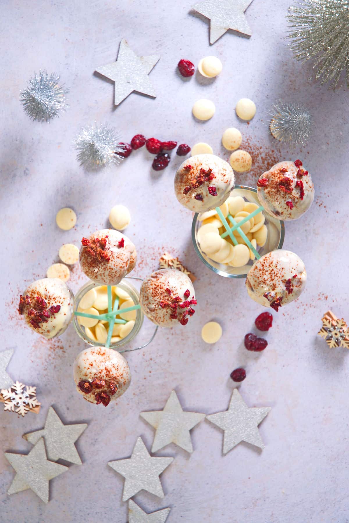 Cranberry white chocolate cake pops in jars with Christmas decorations.