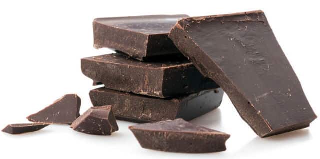 Dark chocolate pieces, white background.
