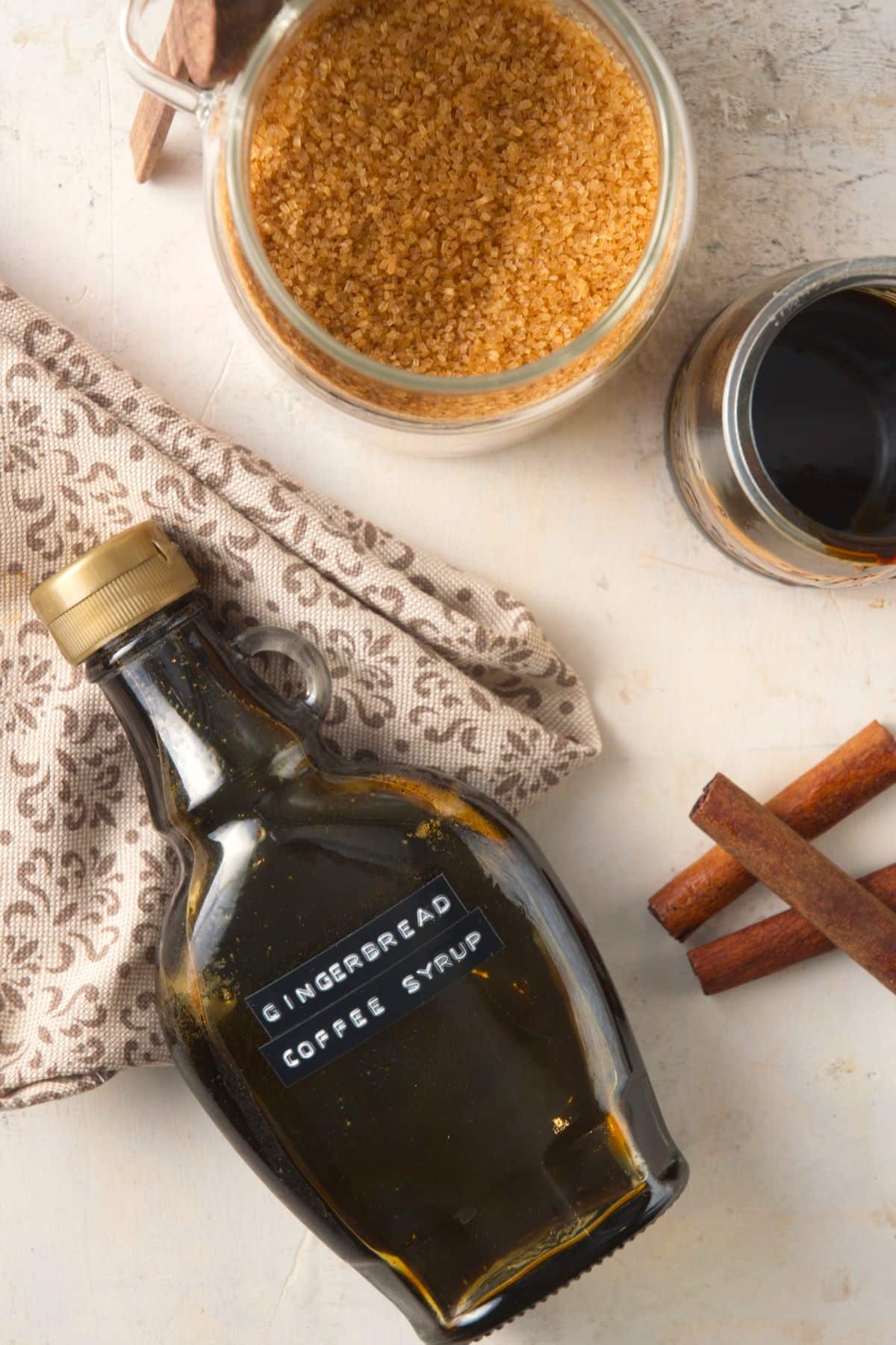 Gingerbread syrup in a syrup jar and brown sugar.