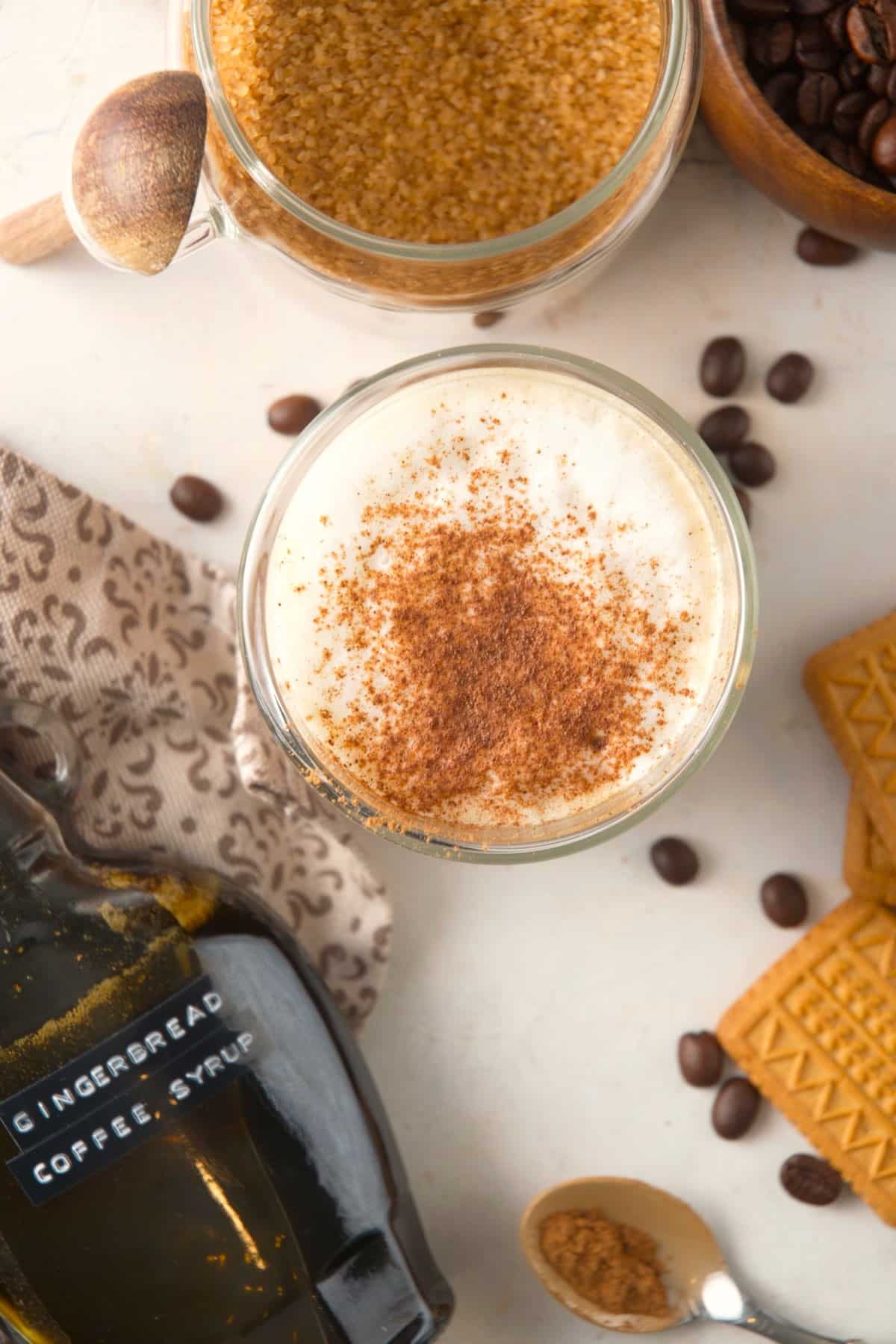 Gingerbread latte in a mug and a bottle of gingerbread syrup.