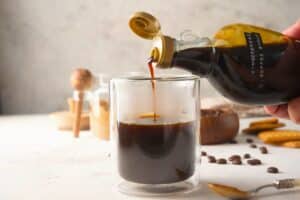 Gingerbread syrup pouring into espresso in a mug.