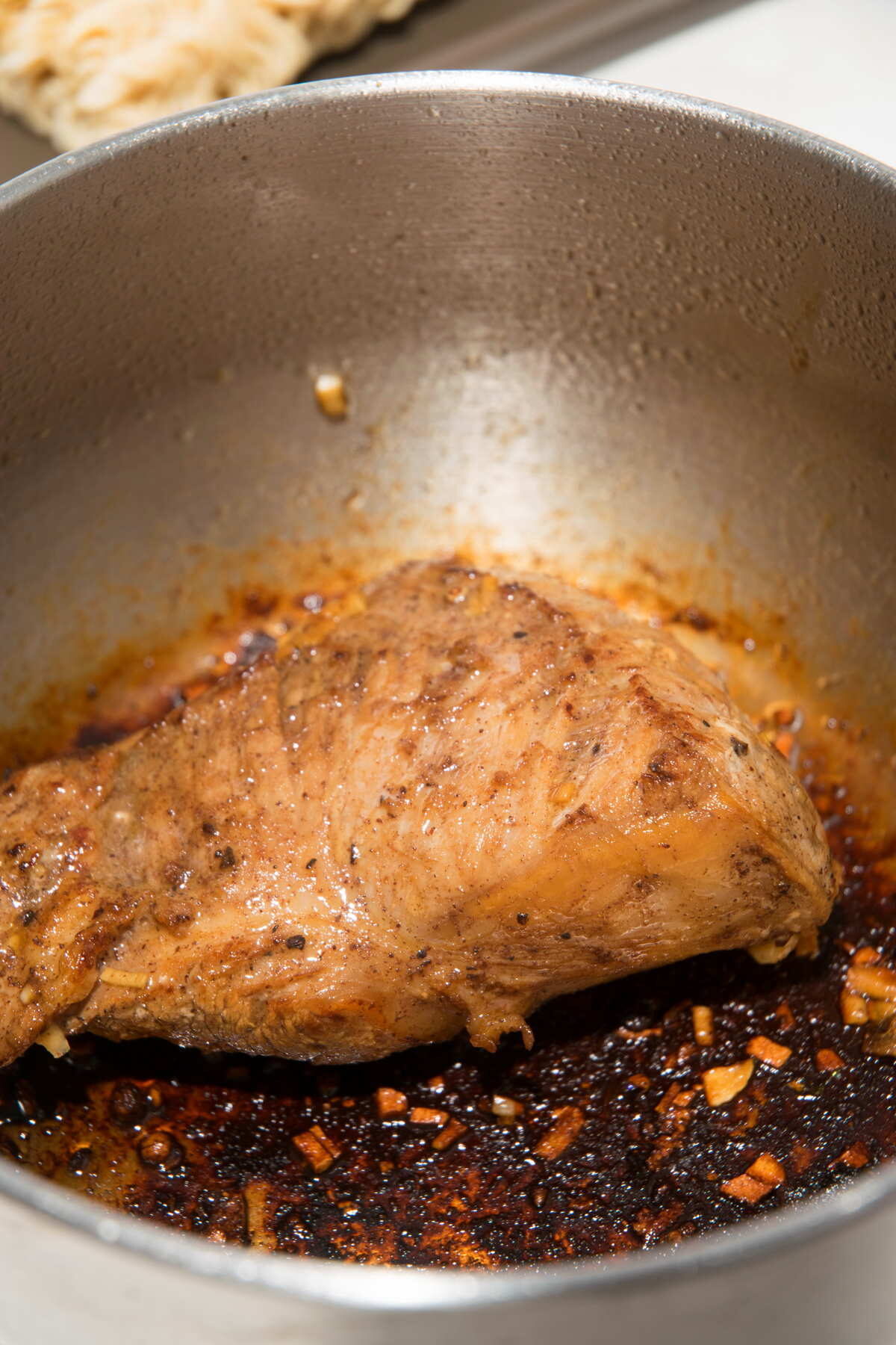Seared pork tenderloin in a large pot.