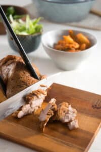 Pork being sliced on a cutting board.