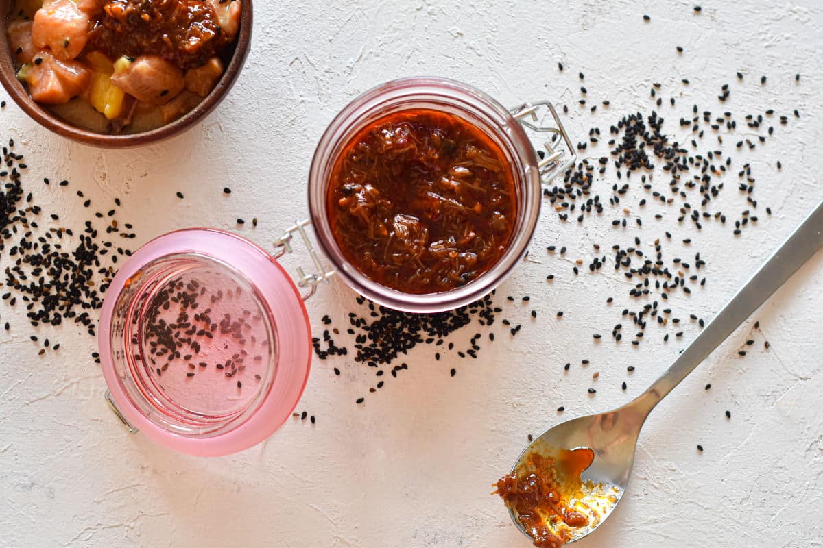 XO sauce in a jar and a spoon on the side on white background.